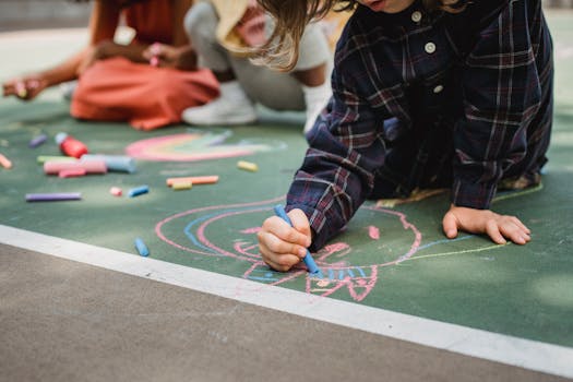 Kids enjoying creative drawing with colorful chalk outdoors on a playground.