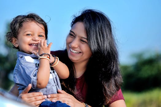 A candid moment capturing a smiling mother and her young child enjoying a sunny day outdoors.